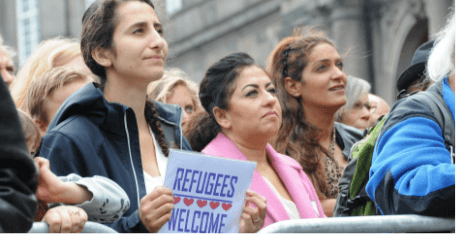 many women at a rally showing support for refugees